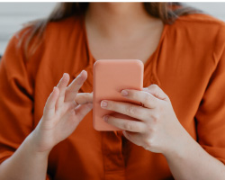 Close-up on the torso of a woman holding a smartphone.