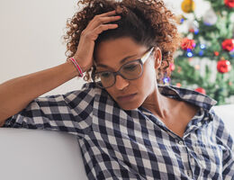  A woman sits on a couch, thinking. 