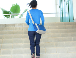 A woman walks away from the camera up a flight of concrete stairs